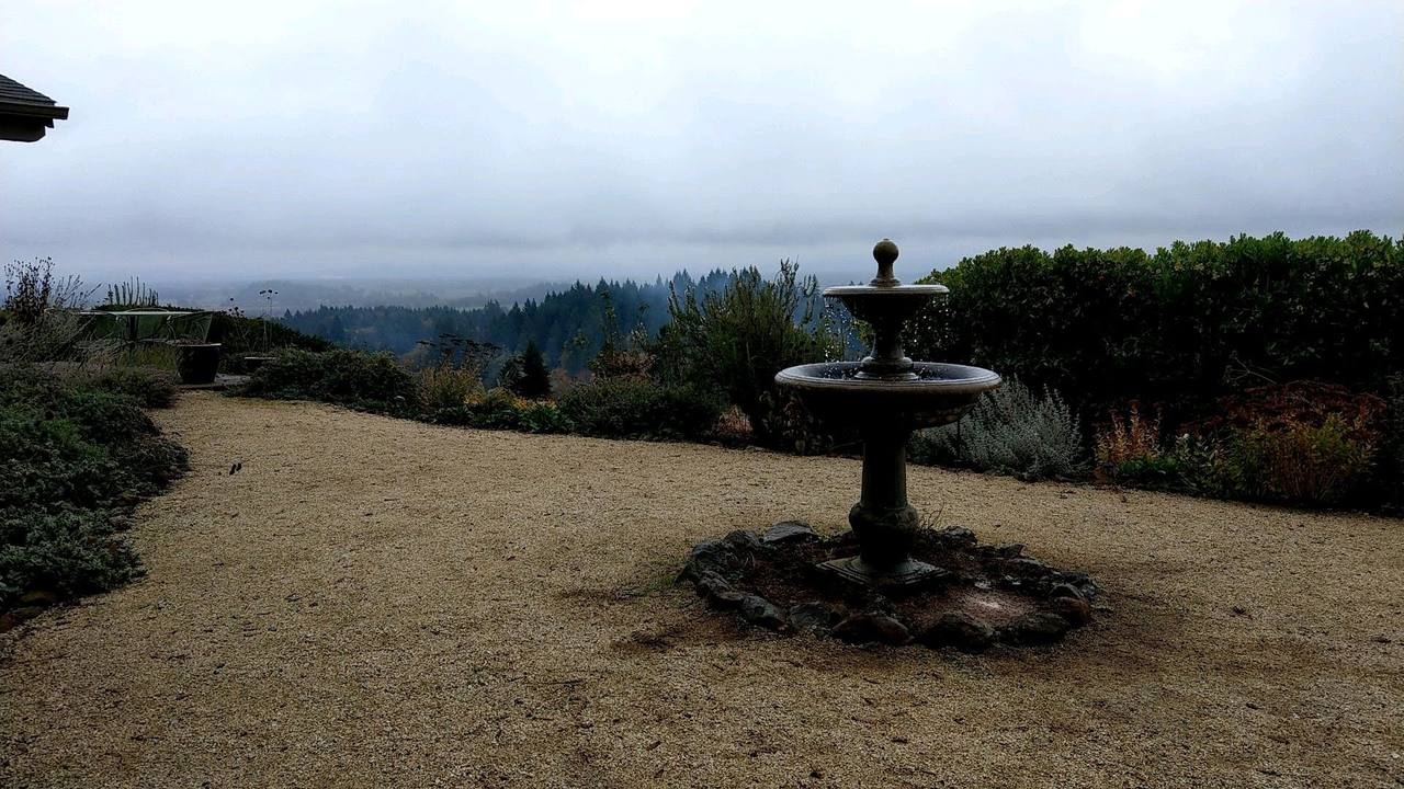 Tiered fountain overlooking a foggy valley